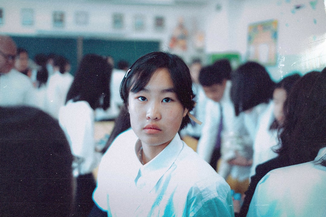 학교 행정실에서 교사가 외국인 학생의 학부모에게 방과후 프로그램 신청 방법을 설명하는 모습