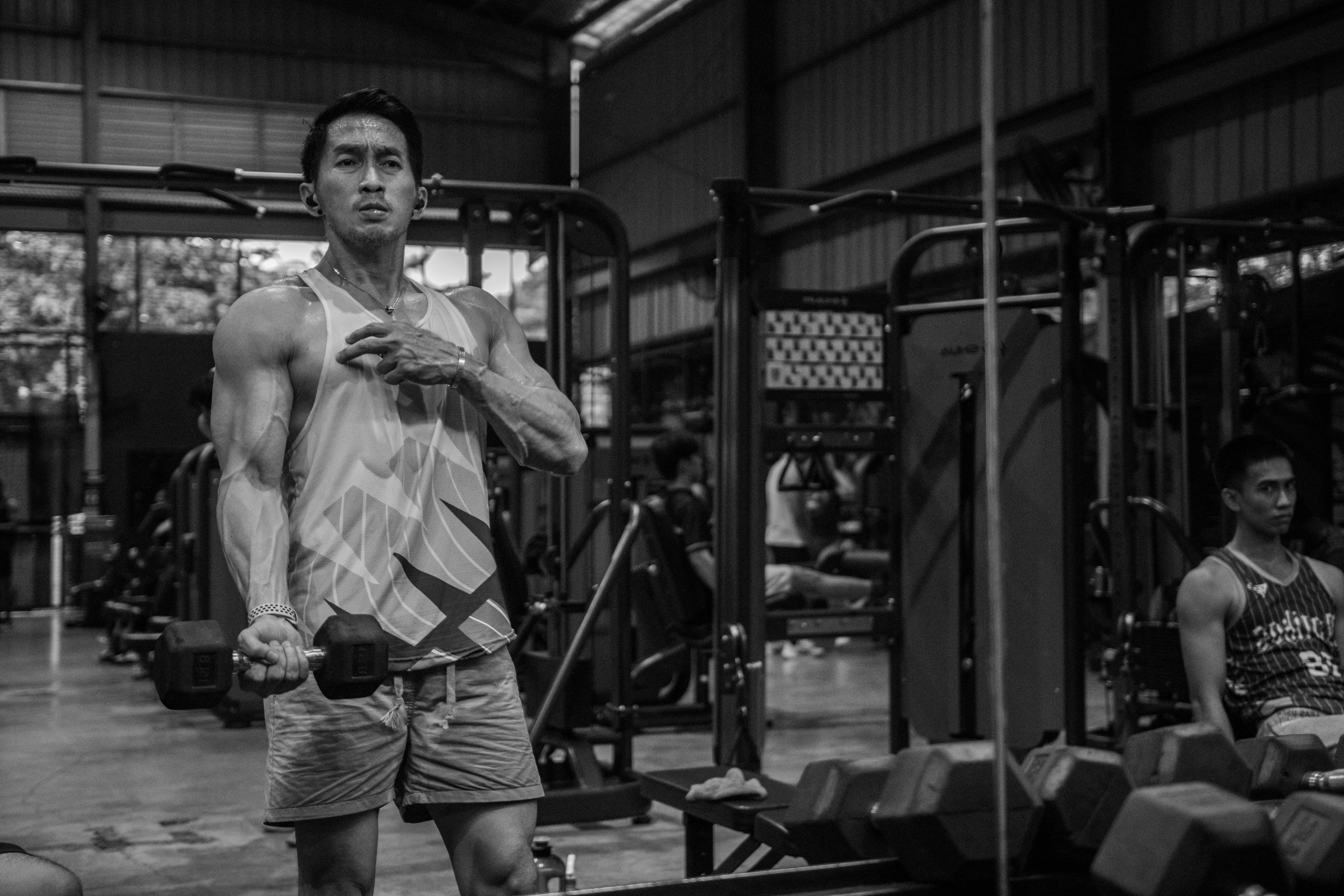 한국 헬스장에서 운동하는 다양한 국적의 외국인들. 러닝머신을 뛰거나 역기를 드는 모습이 현대적인 분위기의 밝은 공간에서 역동적으로 표현됨.